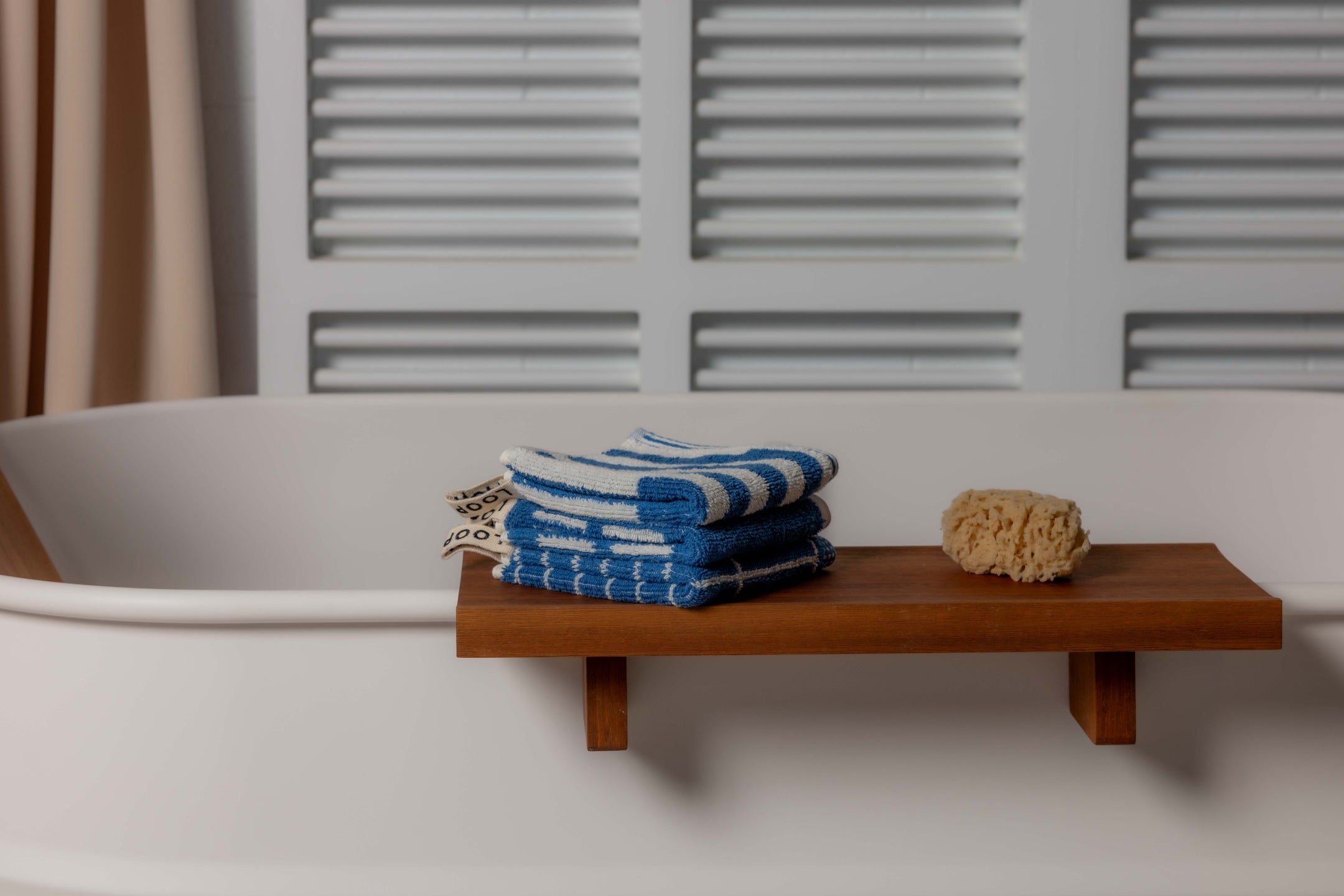 Loop Home organic cotton towels in earthy tones draped over natural surfaces